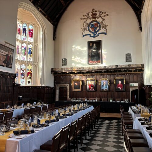 Christ's College Dining Hall set up for a Christmas event with the sunshine shining through the windows.