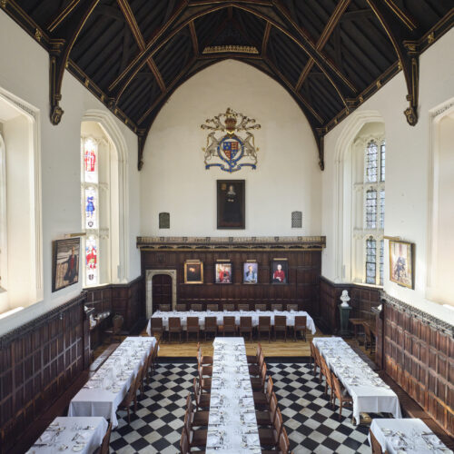 Christ's College Dining Hall with the sunshine shining through the stained glass windows.