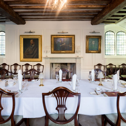 The Portrait Room at Christ’s College, Cambridge, featuring historic framed portraits displayed along traditional panelled walls.