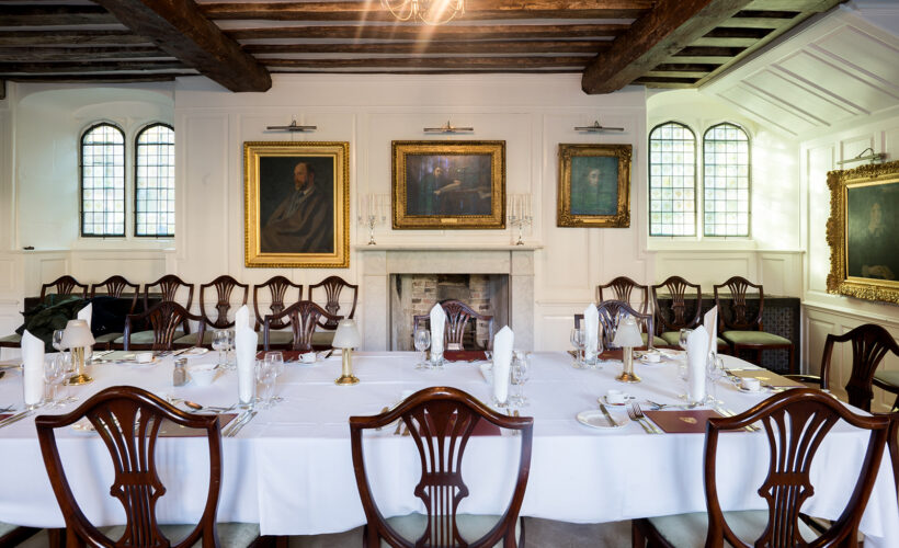The Portrait Room at Christ’s College, Cambridge, featuring historic framed portraits displayed along traditional panelled walls.